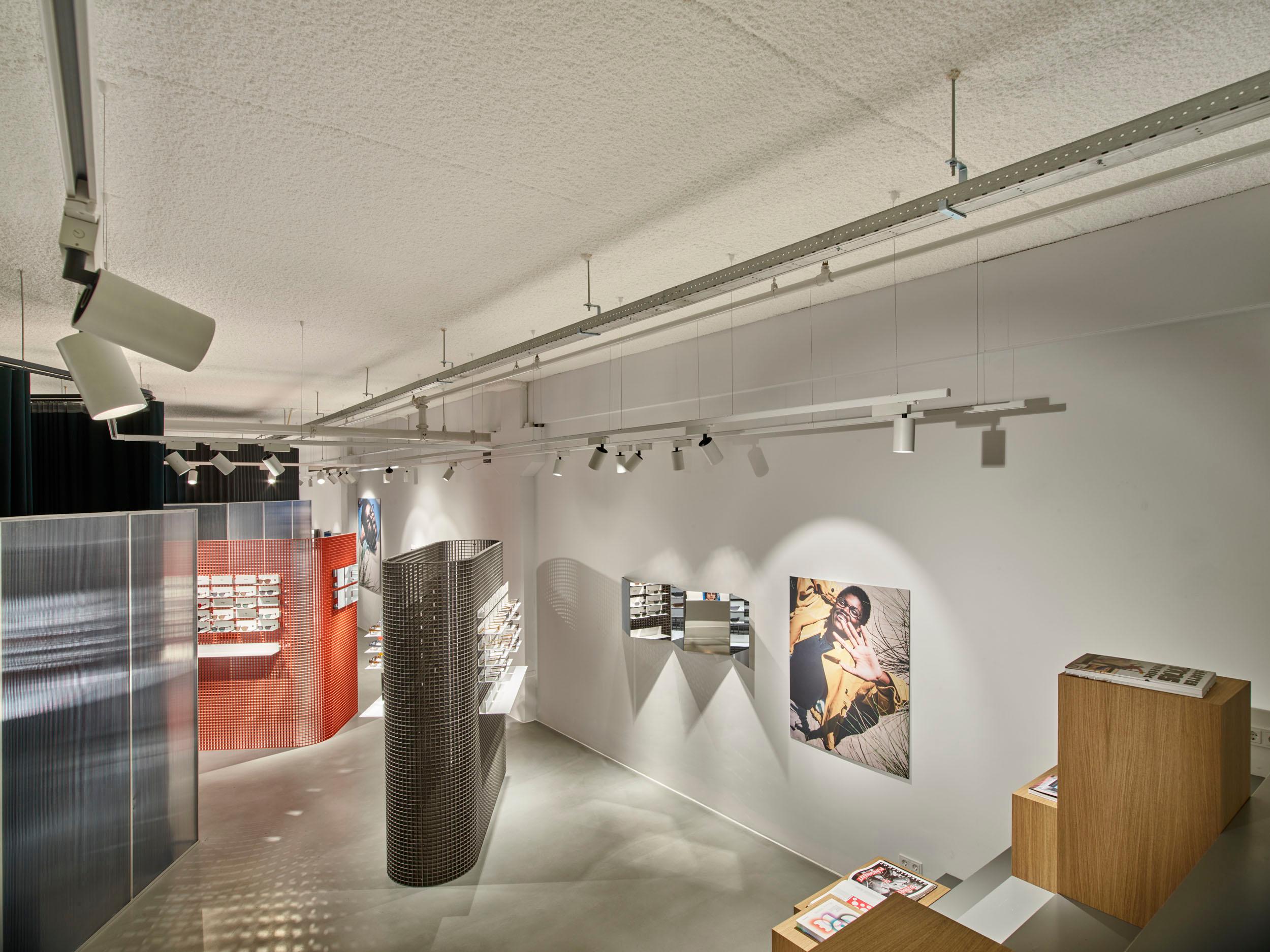 Acospray DC3 naadloos akoestisch plafond in open winkelruimte van Ace & Tate Amsterdam door Acosorb
