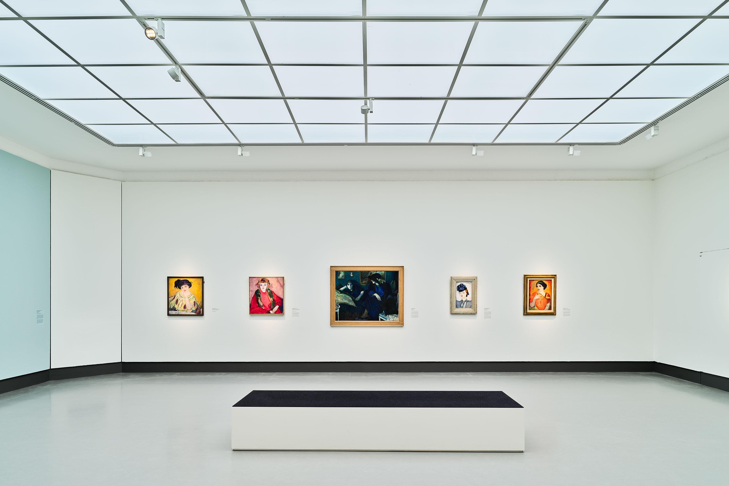 Modern art gallery interior with paintings displayed on white walls