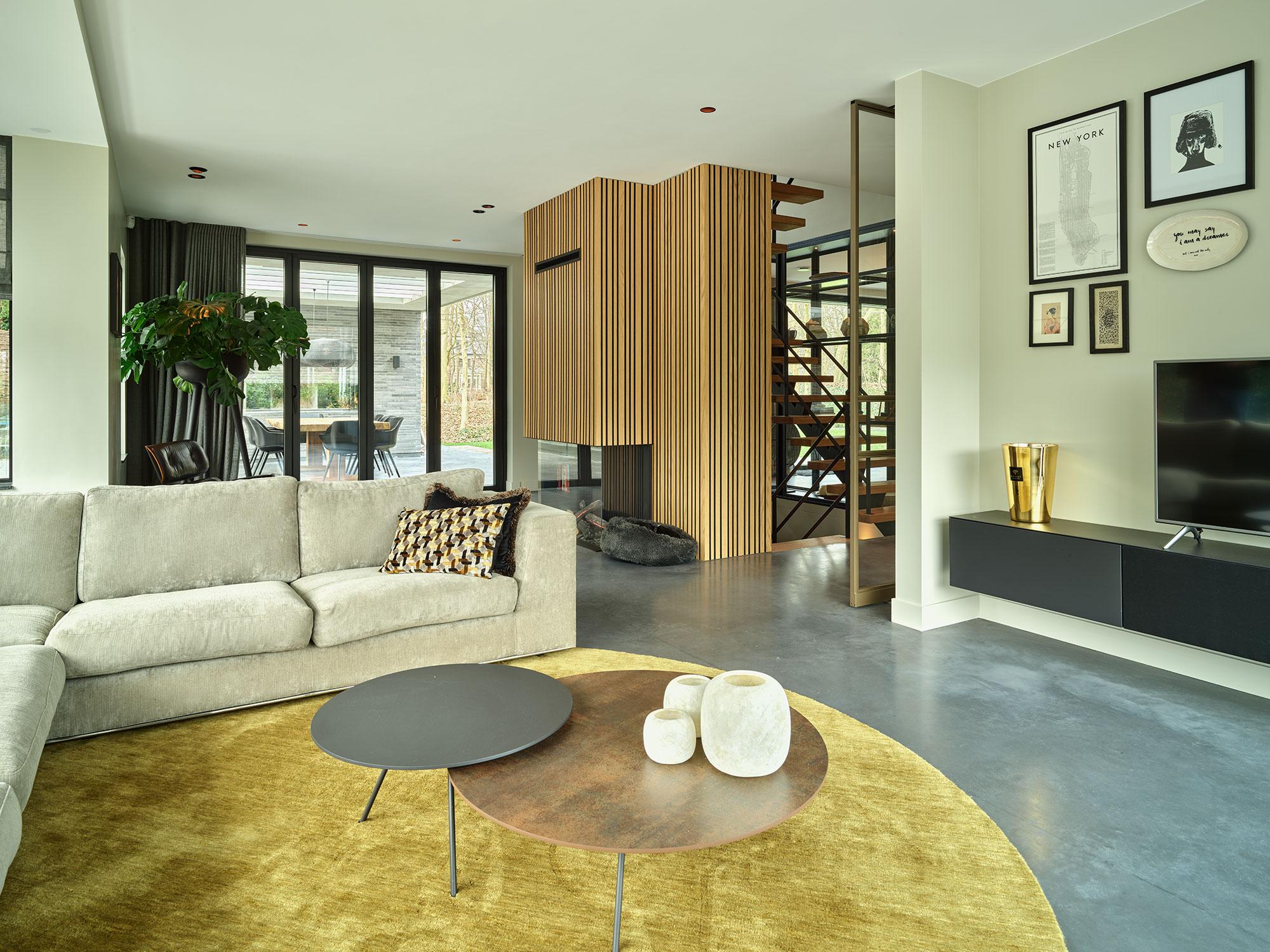 akoestisch plafond in een moderne leefruimte met een felgeel tapijt en houten wanden, die een frisse en comfortabele sfeer biedt.