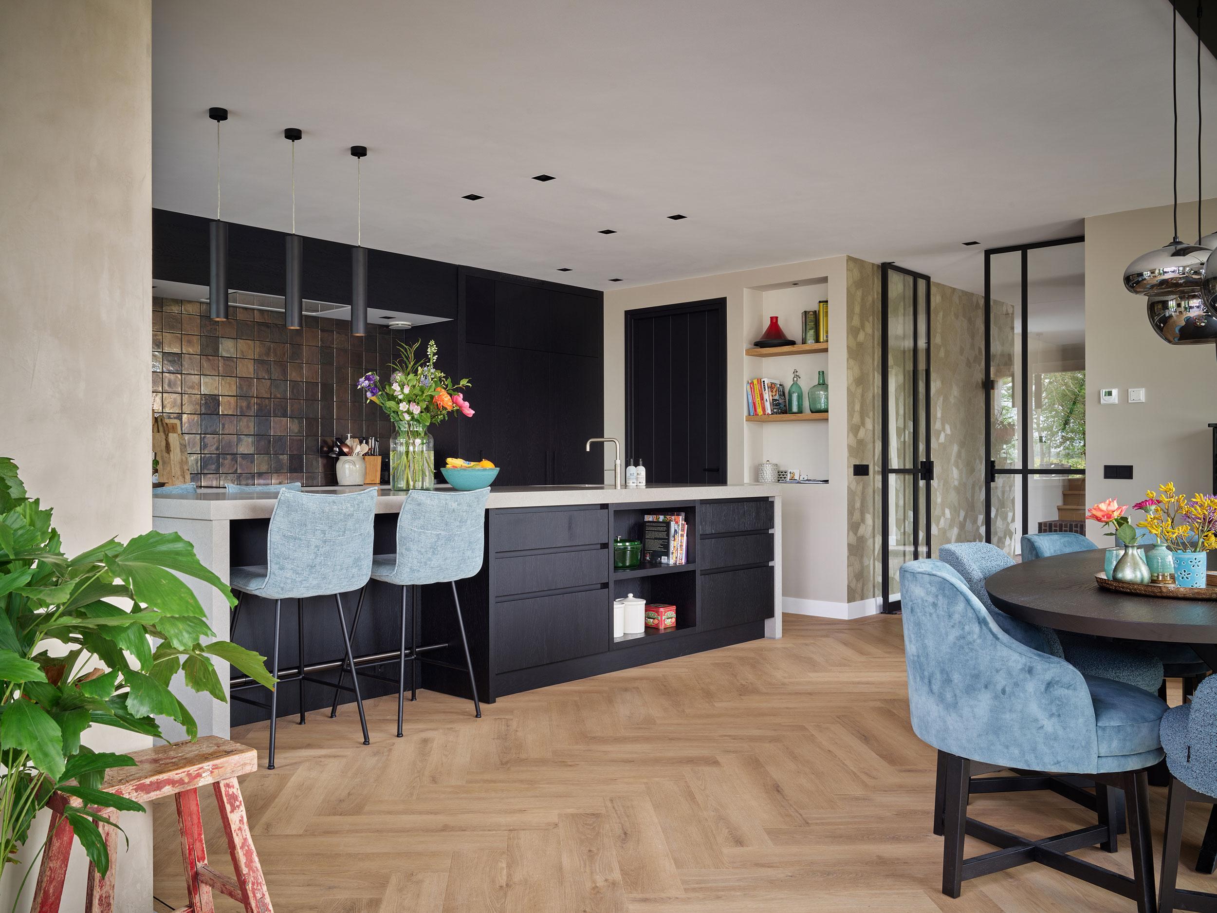 Akoestisch spuitwerk in een open concept keuken met kookeiland.