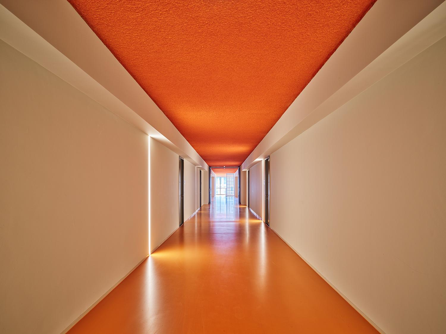 Orange acoustic ceiling in a hallway with Acosorb panels