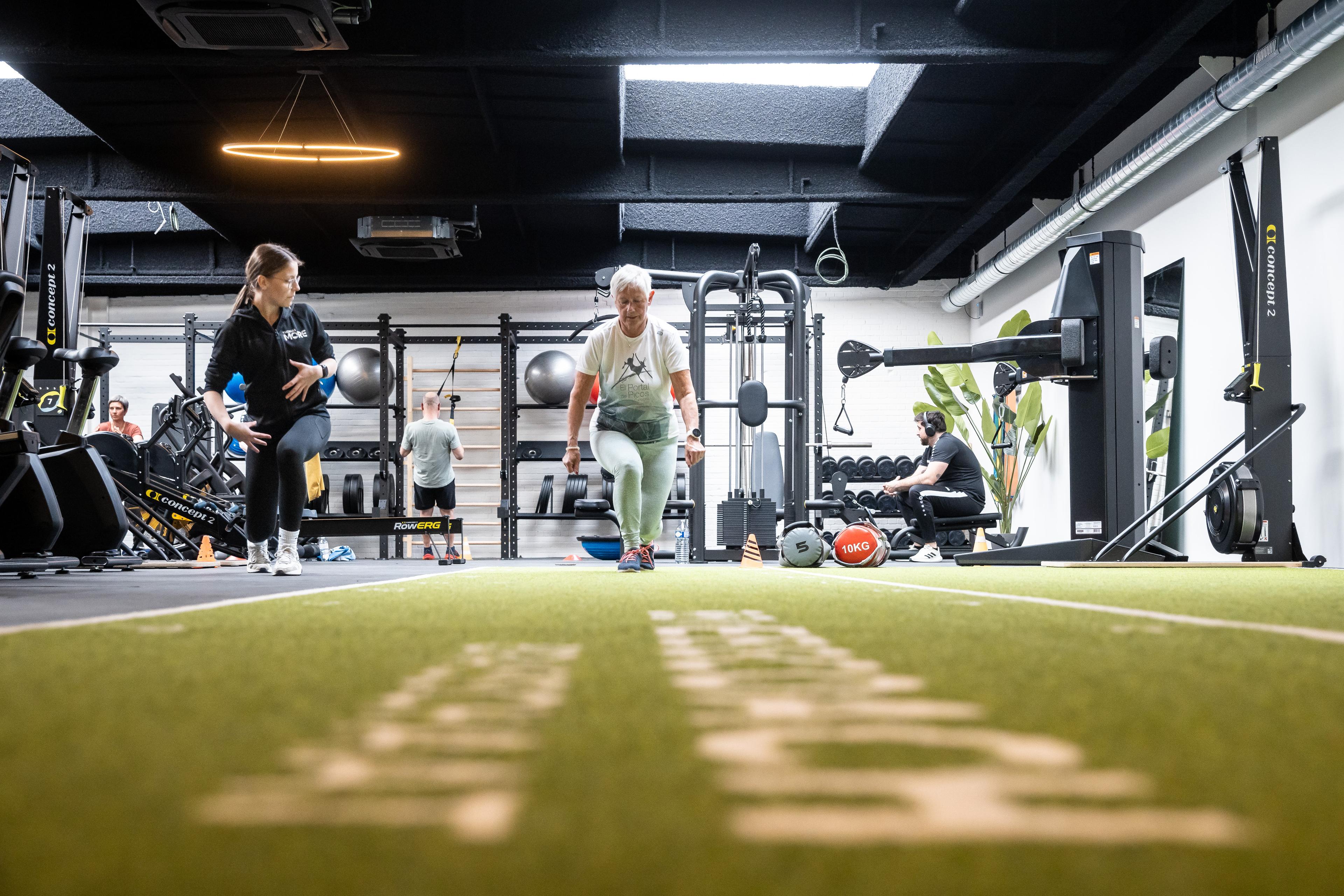 Beweegcoach Brasschaat met Acospray® DC3 in Basic Black aangebracht door Acosorb. Het donkere akoestisch spuitwerk absorbeert galm in de open trainingsruimte en versterkt de premium boutique gym-uitstraling.